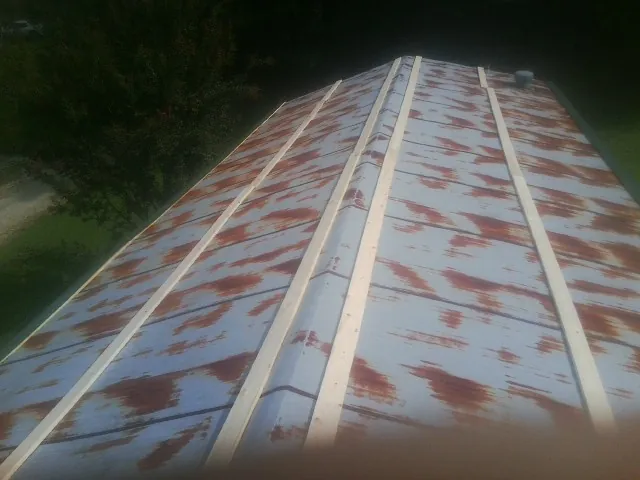 Rusted metal roof panels with new wood purlins before replacement — Storm Damage Roof Repair in Gwynn Oak by Roofing Brothers