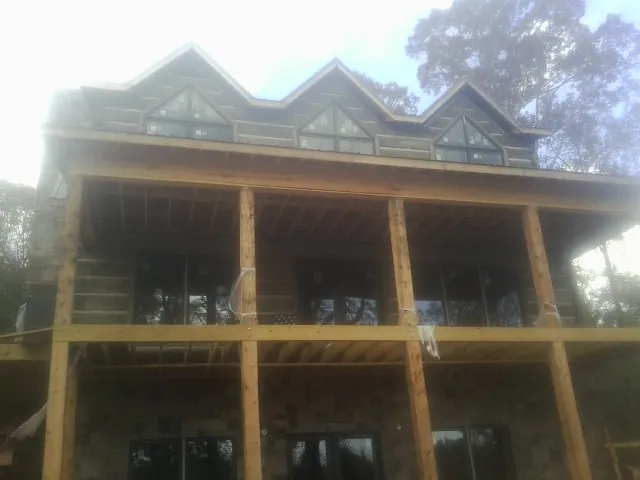 Dormers and porch framing on a large log home under construction — Roof Coating work by our crew in Gwynn Oak