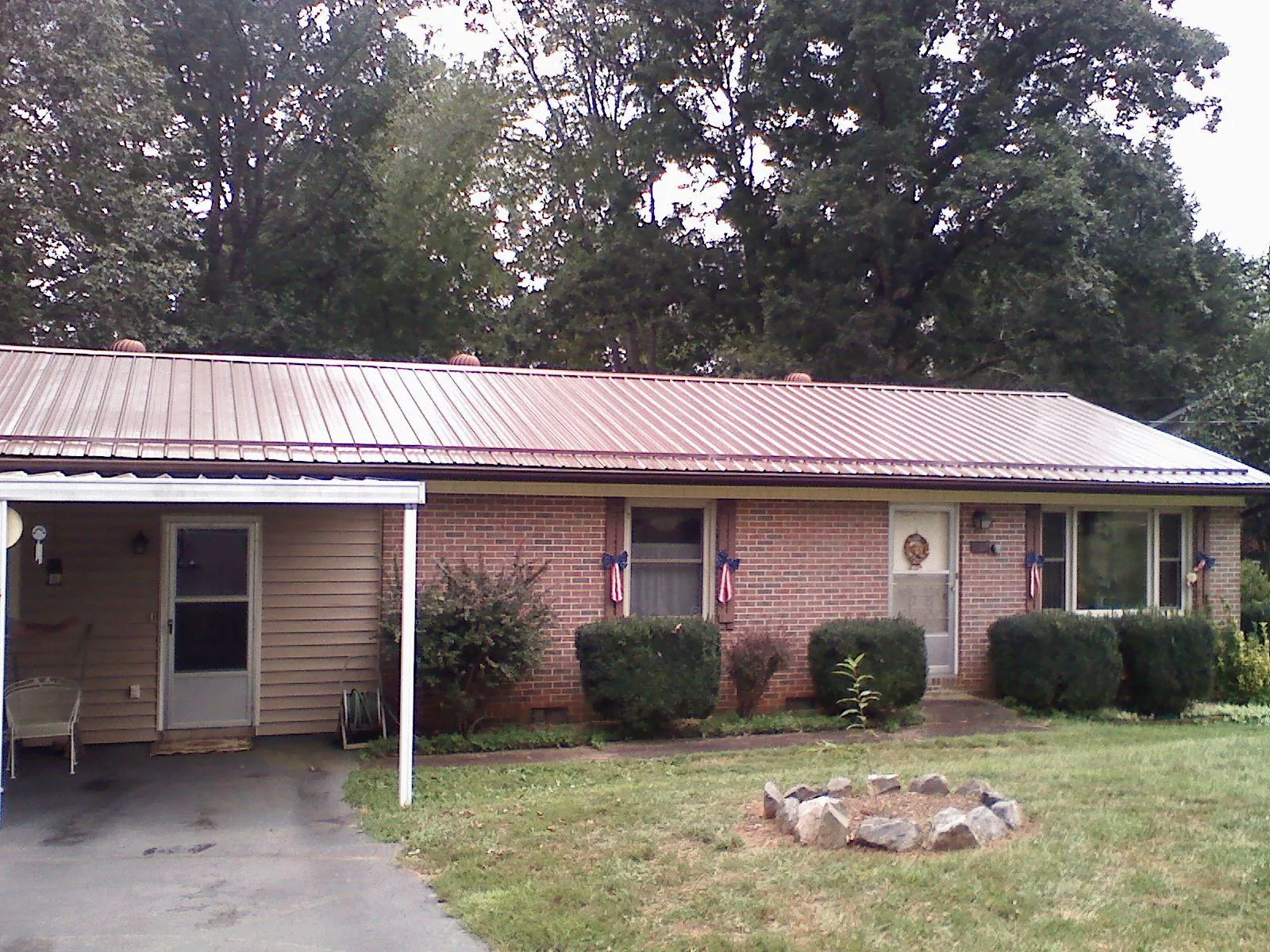 Bronze metal roof and carport on a brick ranch home — Roof Repair work by our crew in Gwynn Oak